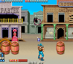 Wild West shooting game scene featuring a cowboy aiming at targets among barrels and buildings.