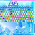 Bright colorful bubble shooter game on icy background with snow and ice formations.
